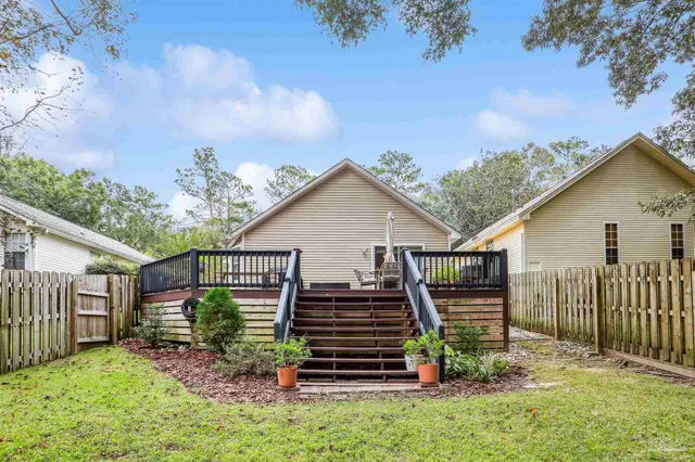 a view of a house with a yard and wooden fence