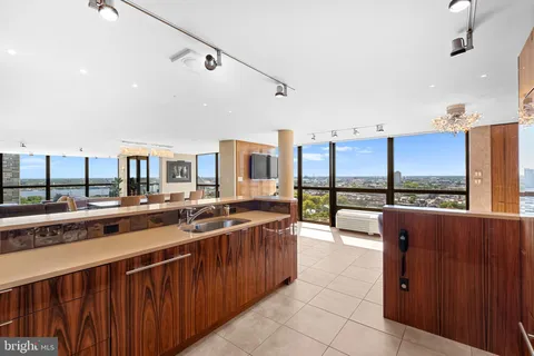 a large kitchen with stainless steel appliances a large counter top a stove and a refrigerator