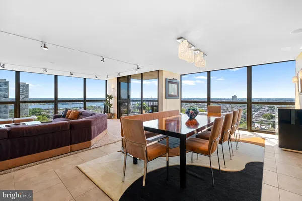 a dining room with furniture large windows and a rug