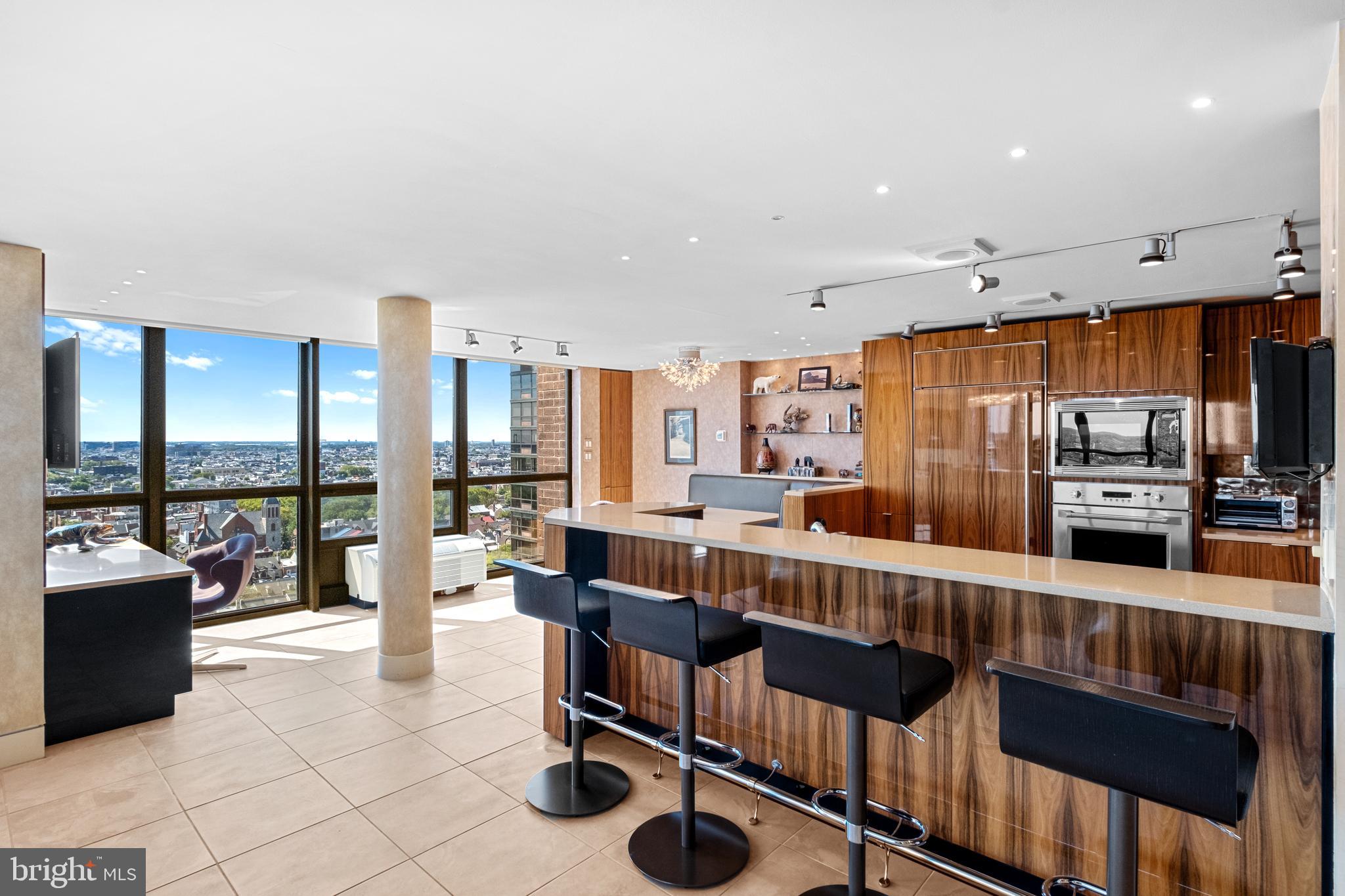233 South 6th Street, Unit 2009 Philadelphia, PA 19106 - Photo 2 of 55 a large living room with stainless steel appliances kitchen island granite countertop a table chairs and a large window