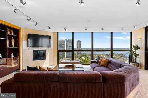 a living room with a balcony a bed and a large window