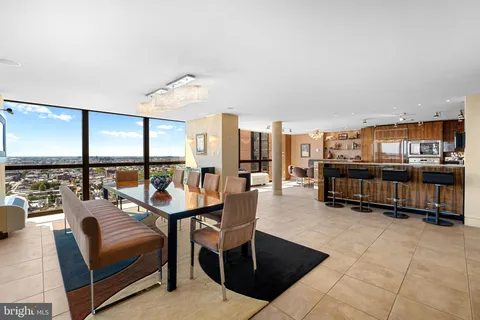 a living room with furniture a rug and a floor to ceiling window