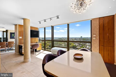 a dining room with furniture and a floor to ceiling window