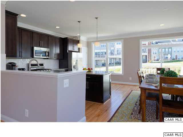 2120 Avinity Loop Charlottesville, VA 22902 - Photo 7 of 24 a kitchen with stainless steel appliances kitchen island granite countertop a sink a stove a dining table and chairs