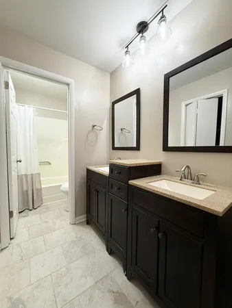 a spacious bathroom with a granite countertop sink mirror and shower
