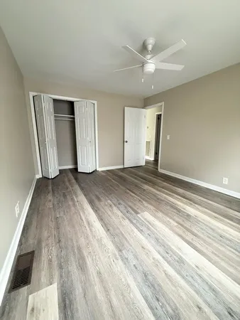 an empty room with wooden floor and windows