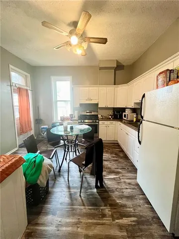 a kitchen with a table chairs refrigerator and cabinets