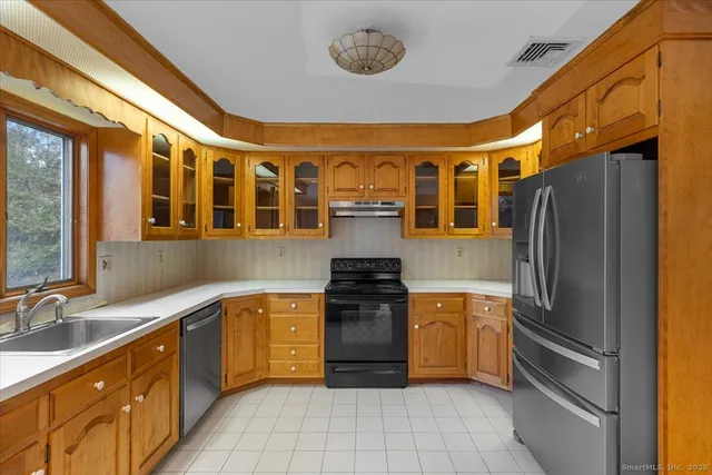 a kitchen with stainless steel appliances granite countertop a refrigerator and a sink