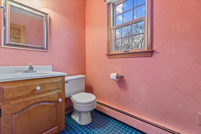 a bathroom with a granite countertop toilet and a sink