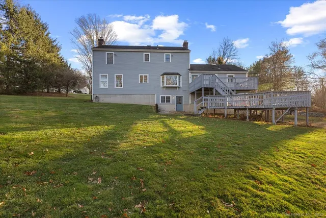 a view of a house with a big yard next to a large tree