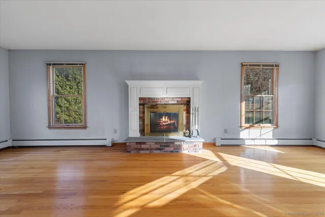 a view of an empty room with window and a fireplace