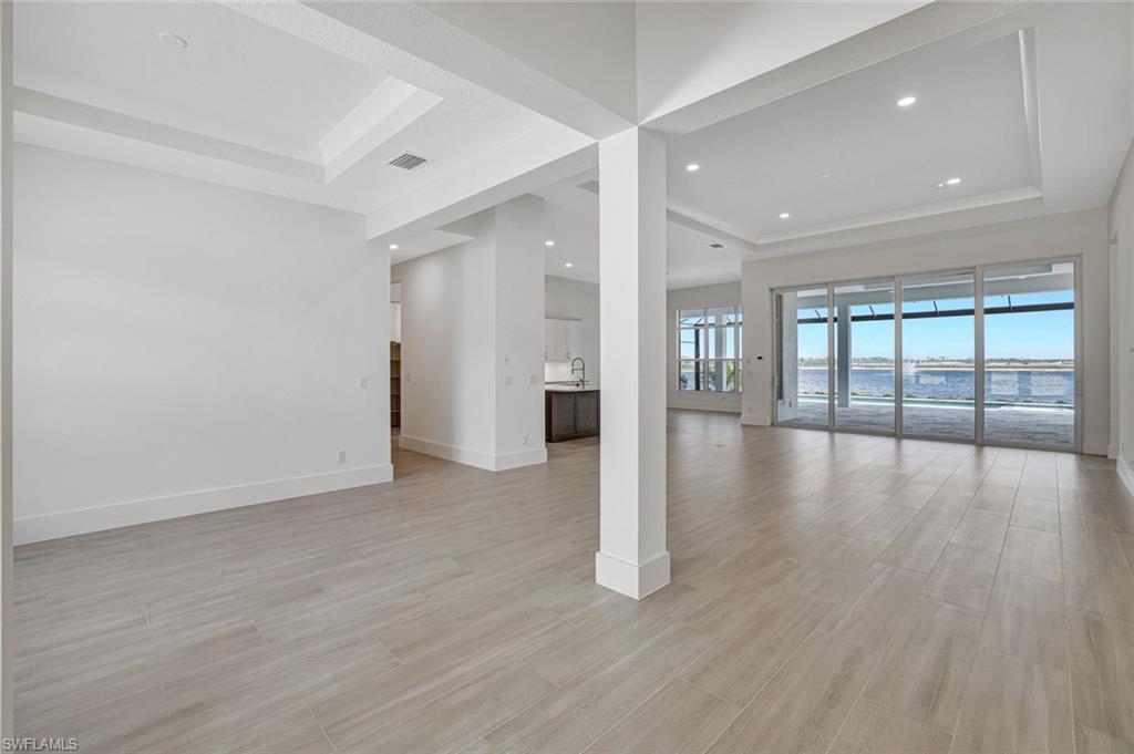 9506 Caymas Way Naples, FL 34114 - Photo 14 of 50 a view of an empty room with wooden floor and a window