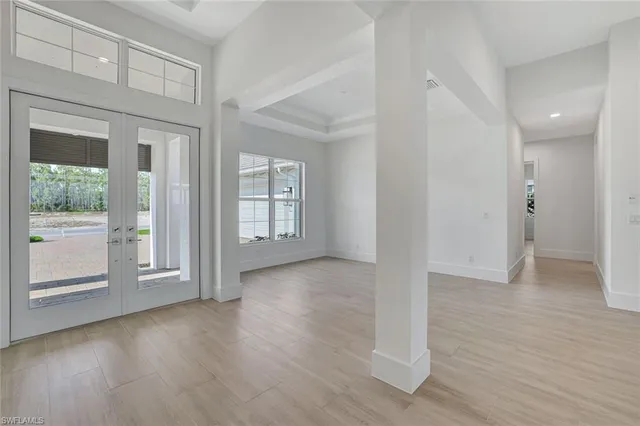 an empty room with wooden floor and a ceiling fan