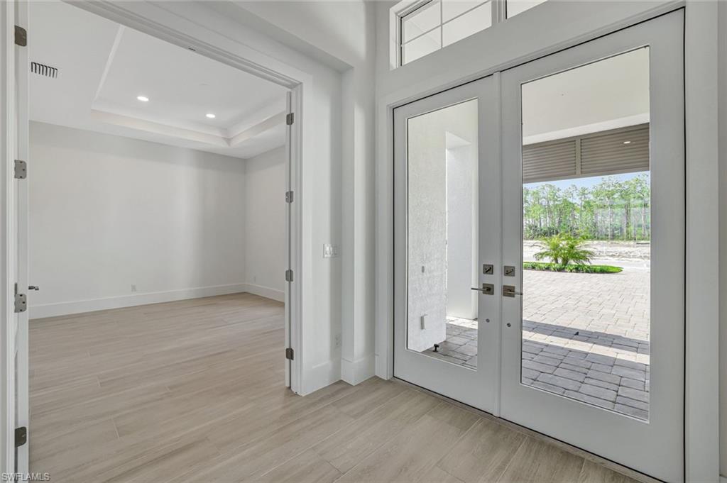 9506 Caymas Way Naples, FL 34114 - Photo 17 of 50 an empty room with wooden floor and a ceiling fan