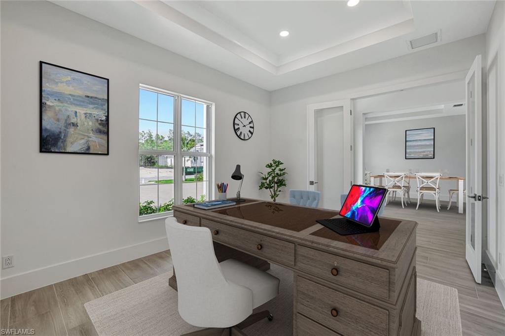 9506 Caymas Way Naples, FL 34114 - Photo 17 of 50 Office space featuring a tray ceiling, light wood-style floors, and recessed lighting