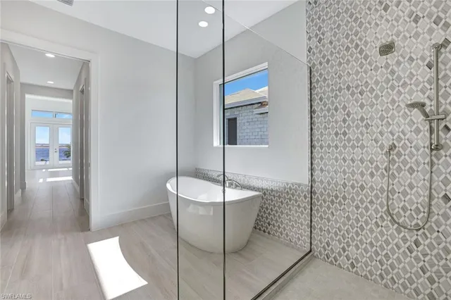 a white bath tub sitting next to a shower