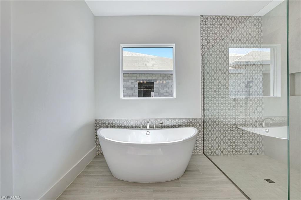 9506 Caymas Way Naples, FL 34114 - Photo 22 of 50 a white bath tub sitting next to a shower