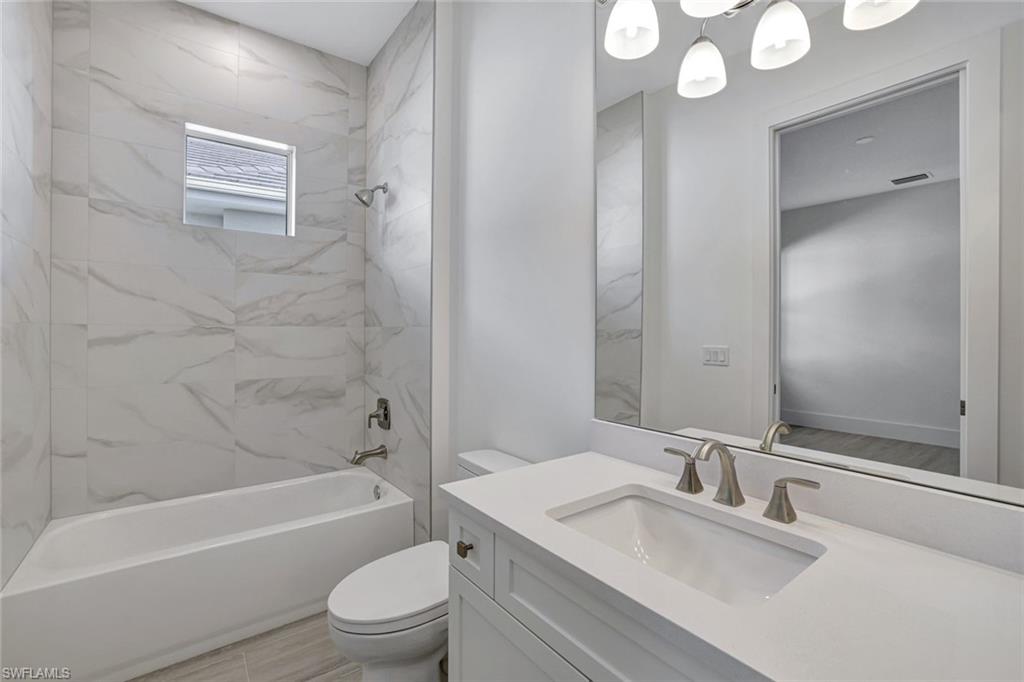 9506 Caymas Way Naples, FL 34114 - Photo 29 of 50 a bathroom with a granite countertop sink toilet and shower