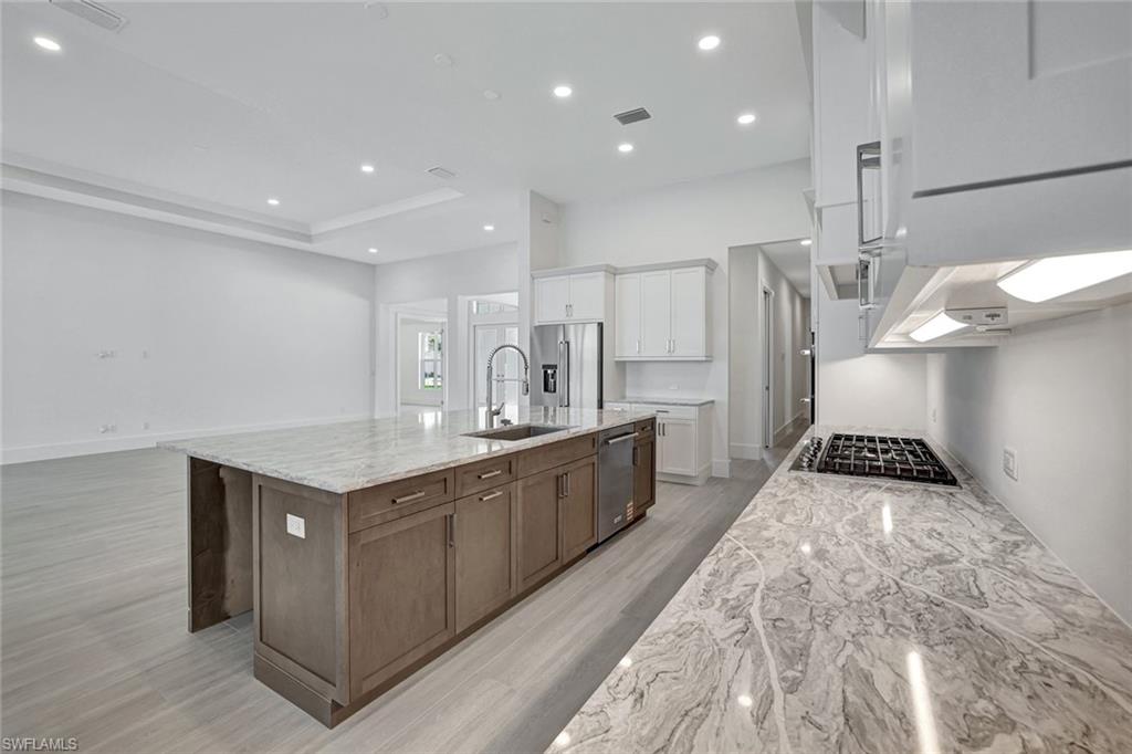 9506 Caymas Way Naples, FL 34114 - Photo 6 of 50 a large kitchen with stainless steel appliances a large counter top a stove a sink and a refrigerator