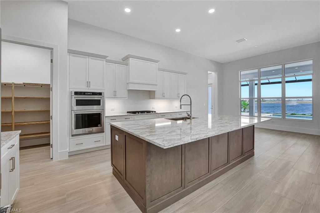 9506 Caymas Way Naples, FL 34114 - Photo 7 of 50 a kitchen with stainless steel appliances granite countertop a stove top oven a sink and a refrigerator