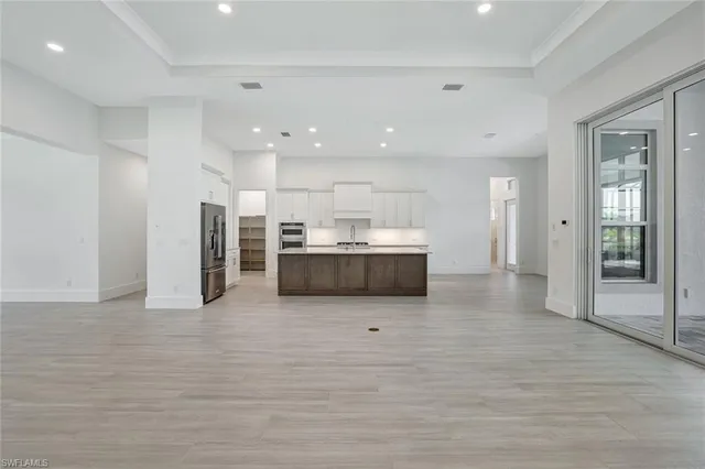 a large white kitchen with a refrigerator and a sink