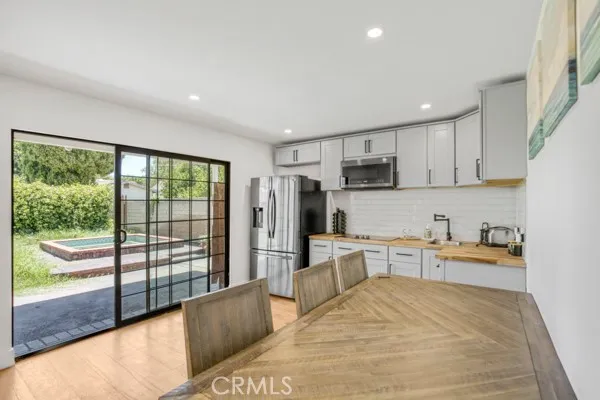 a large kitchen with stainless steel appliances granite countertop a refrigerator sink and cabinets