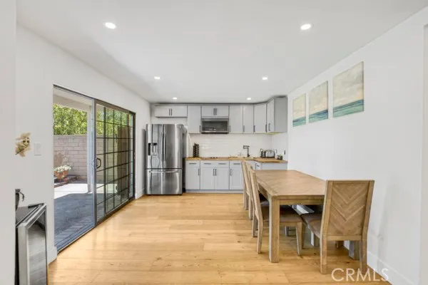 a kitchen with stainless steel appliances refrigerator dining table and chairs
