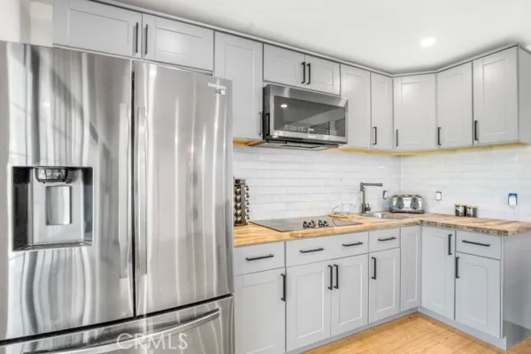 a kitchen with white cabinets and stainless steel appliances