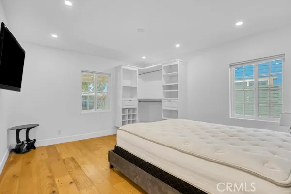 a spacious bedroom with a bed and a flat screen tv