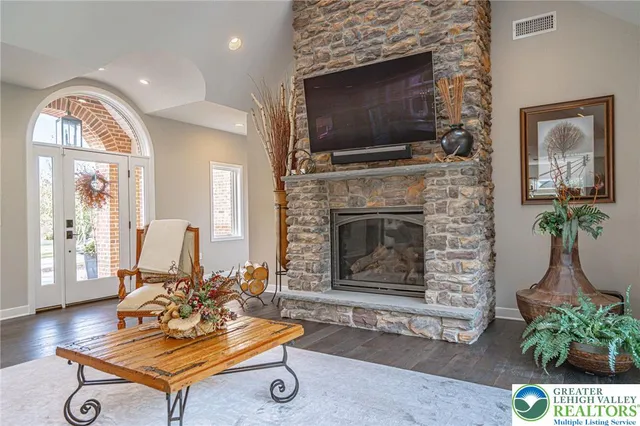 a living room with kitchen island granite countertop furniture a chandelier a sink and a window