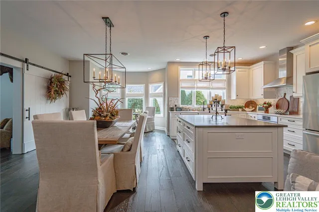 a large kitchen with stainless steel appliances a sink a stove and a refrigerator