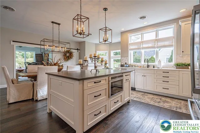 a kitchen with stainless steel appliances kitchen island granite countertop a sink and a refrigerator