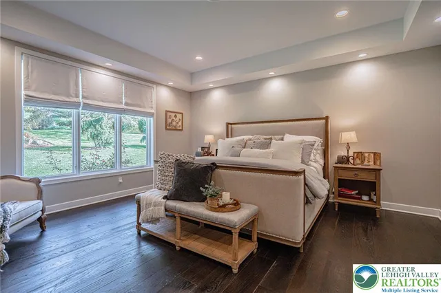 a bathroom with a double vanity sink a large mirror a bathtub and window