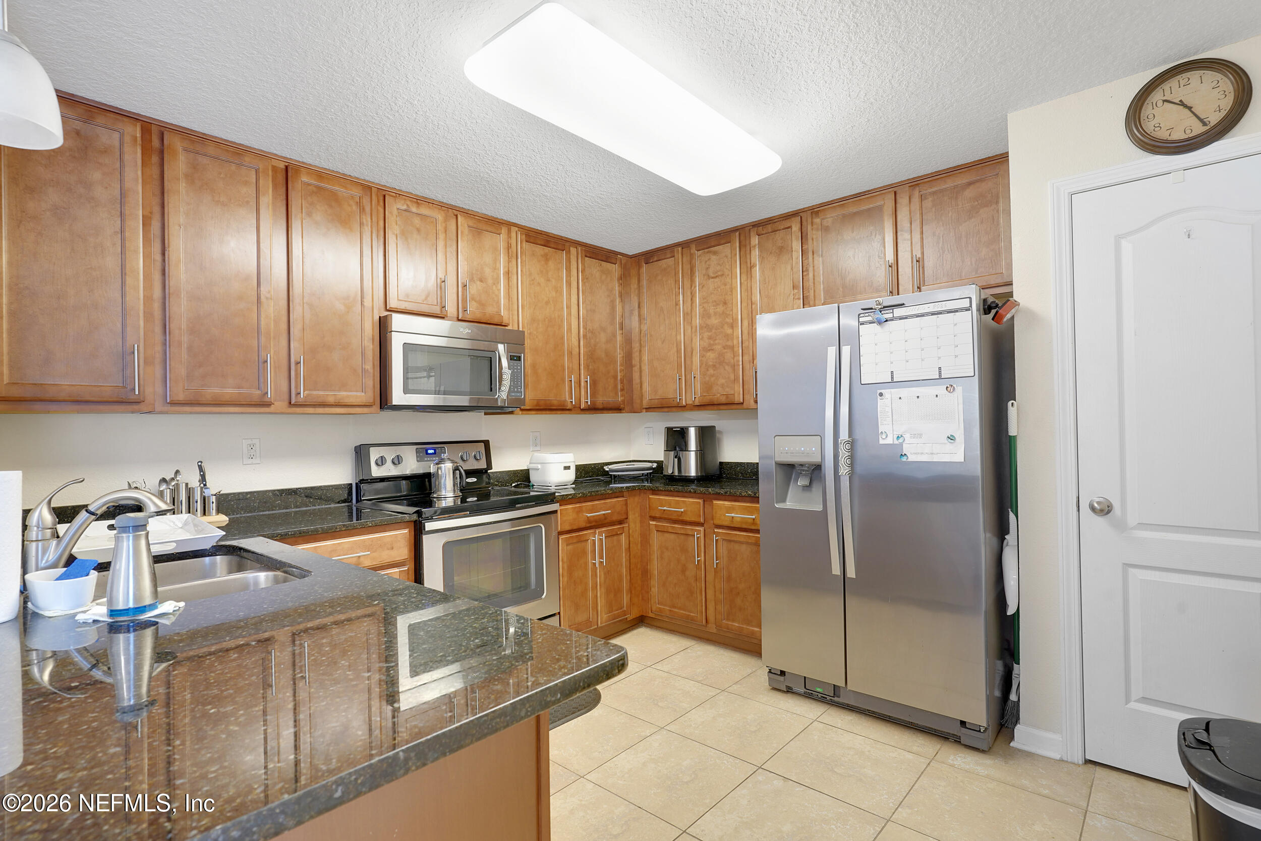 1424 Golden Lake Loop St. Augustine, FL 32084 - Photo 18 of 40 a kitchen with granite countertop stainless steel appliances a refrigerator a stove top oven and cabinets