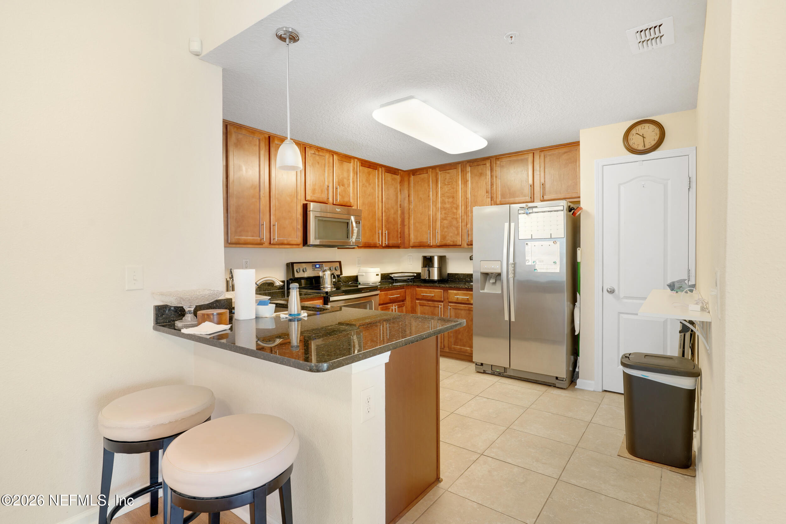 1424 Golden Lake Loop St. Augustine, FL 32084 - Photo 3 of 40 a kitchen with stainless steel appliances granite countertop a sink a stove a refrigerator cabinets and chairs