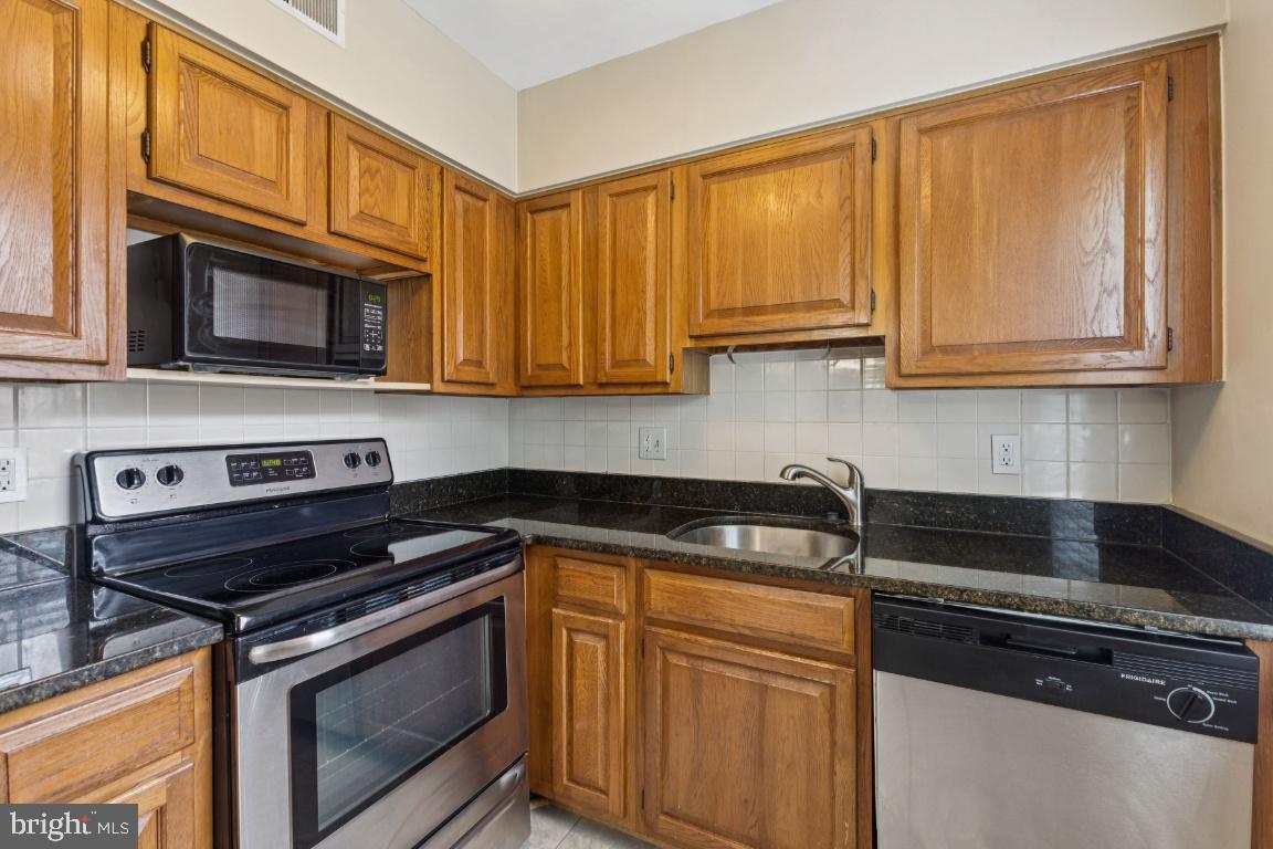 2803 Arlington Boulevard, Unit 101 Arlington, VA 22201 - Photo 6 of 12 a kitchen with granite countertop cabinets stove and microwave