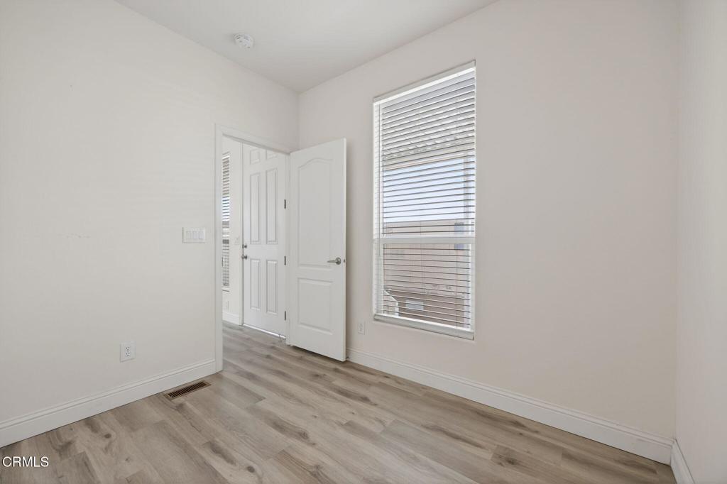 3975 Telegraph Road, Unit 2 Ventura, CA 93003 - Photo 13 of 21 an empty room with wooden floor and windows