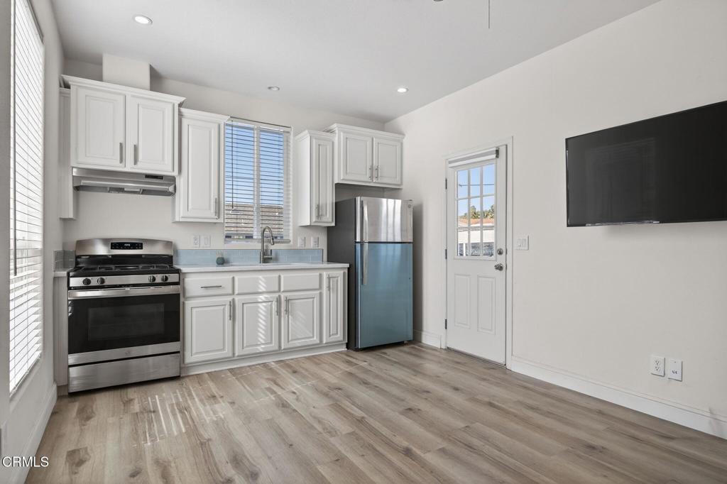 3975 Telegraph Road, Unit 2 Ventura, CA 93003 - Photo 7 of 21 a kitchen with a refrigerator stove and white cabinets