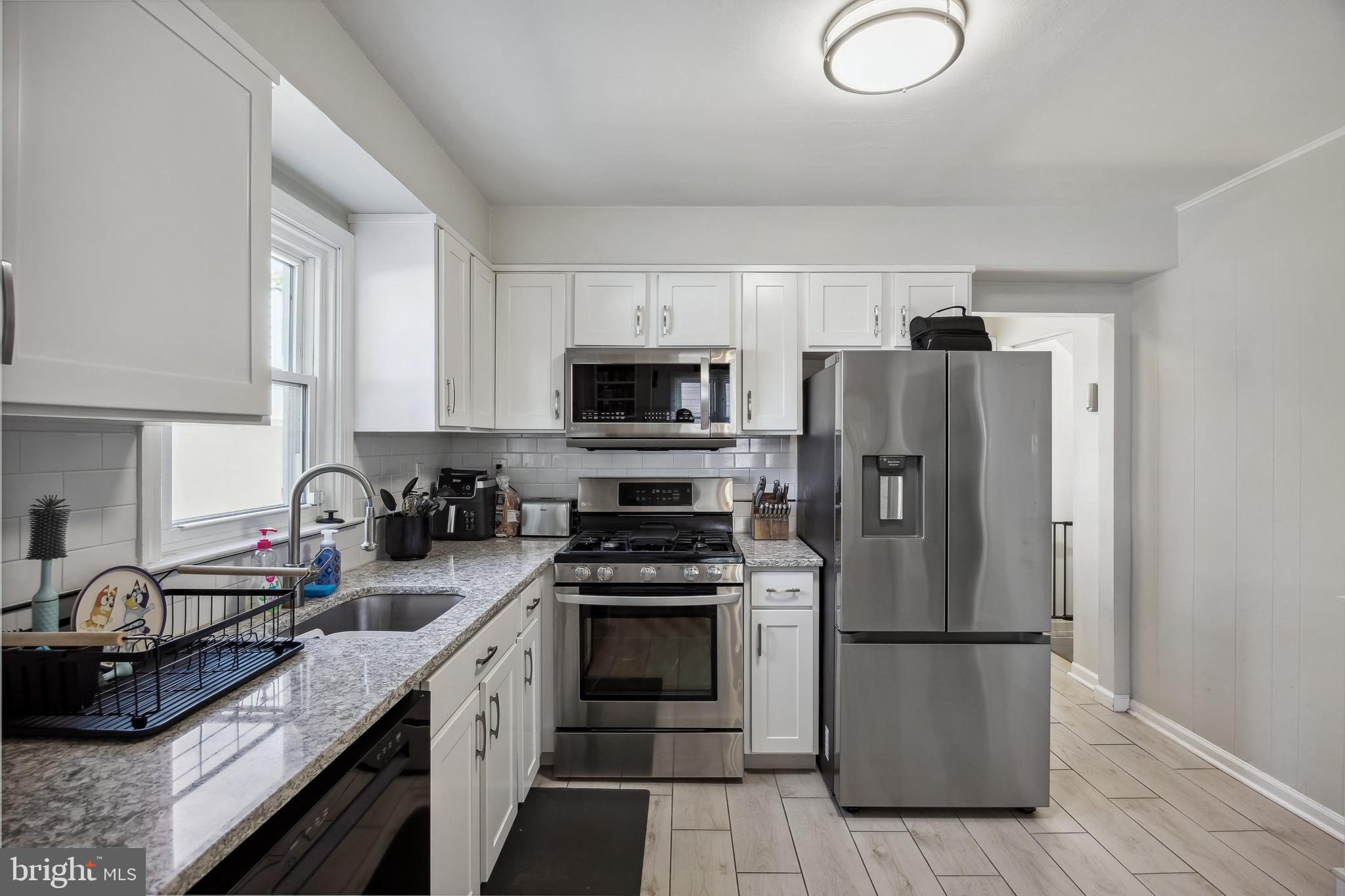 805 Delaware Avenue Riverside, NJ 08075 - Photo 11 of 42 a kitchen with a refrigerator a microwave a sink and cabinets