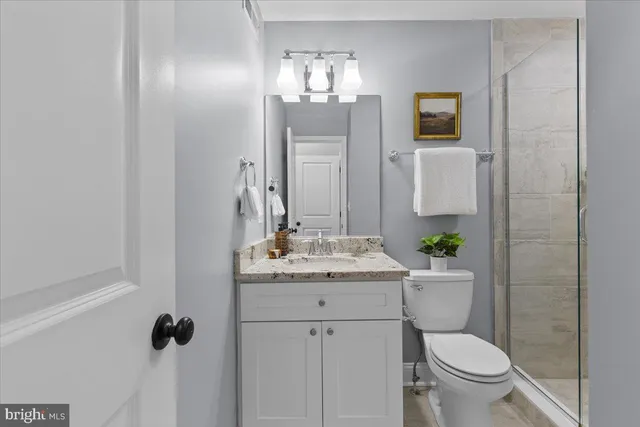 a bathroom with a granite countertop sink toilet and shower