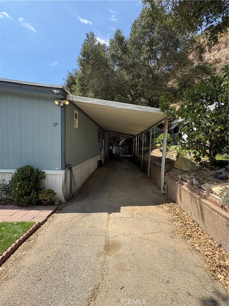23500 The Old Road, Unit 37 Newhall, CA 91321 - Photo 3 of 22 a view of a patio with table and chairs with wooden fence and plants