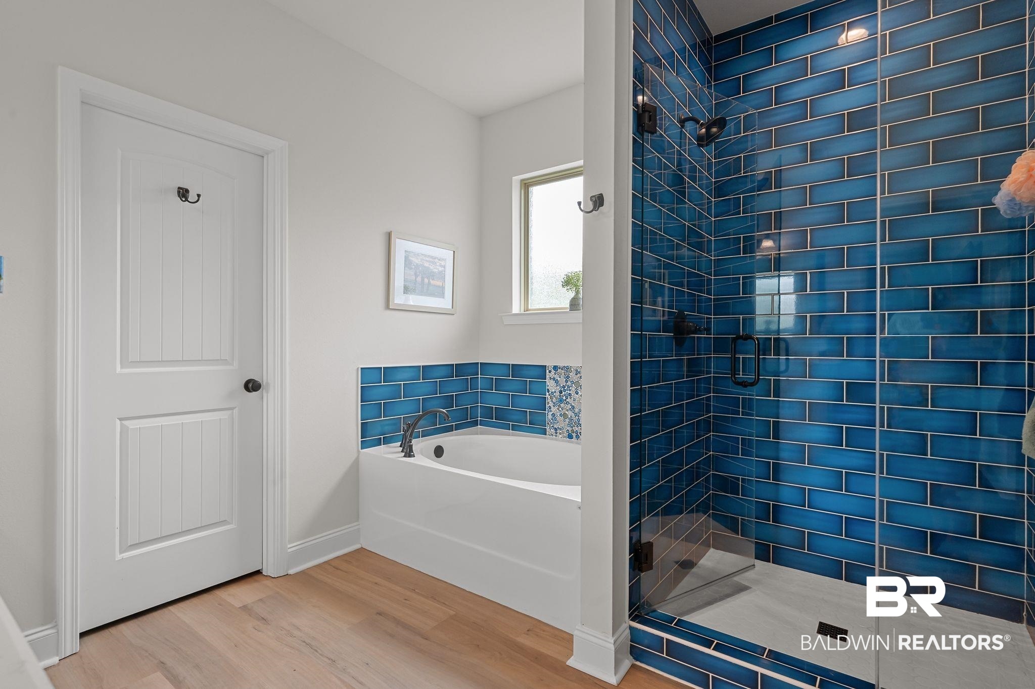 1165 Stella Road Foley, AL 36535 - Photo 21 of 42 Bathroom featuring wood finished floors, a stall shower, a garden tub, and baseboards