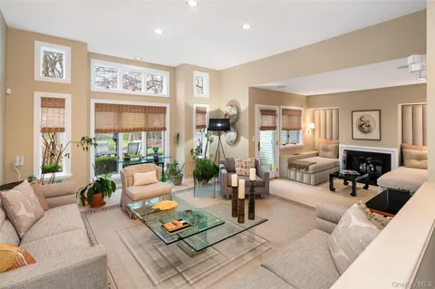 a living room with furniture large window and a table