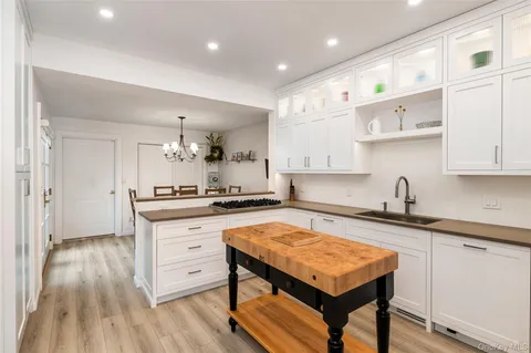 a kitchen with stainless steel appliances granite countertop a table chairs sink and cabinets