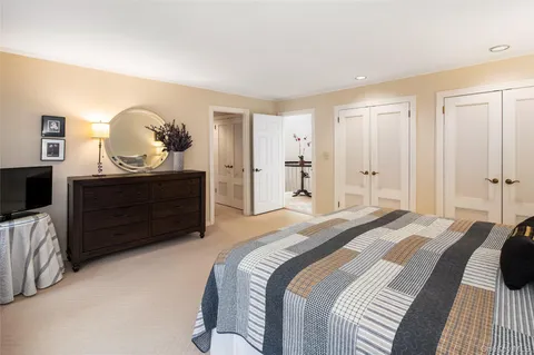 a spacious bedroom with a bed and a dresser