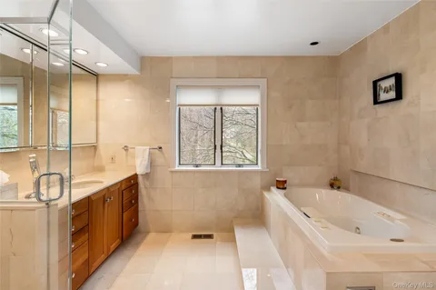 a spacious bathroom with a tub sink and mirror