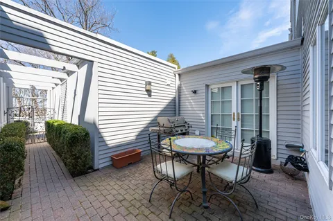 a view of a house with a table and chairs in patio