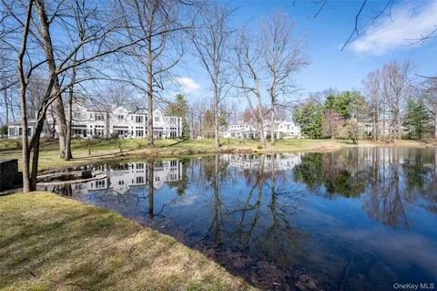 a view of a lake with a bench and trees