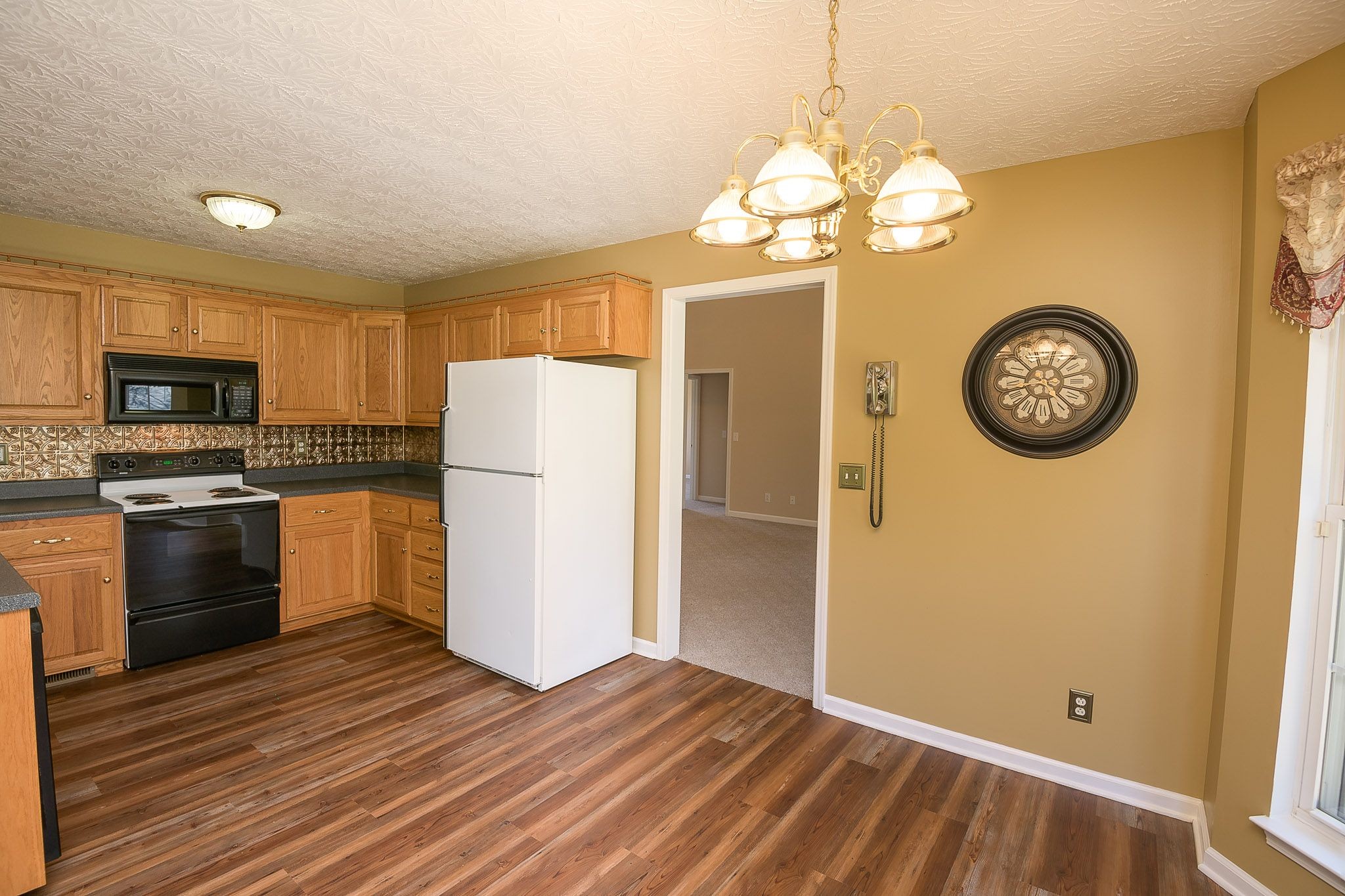 4165 Mt Zion Road Springfield, TN 37172 - Photo 27 of 42 a kitchen with a refrigerator a stove top oven a clock and a window