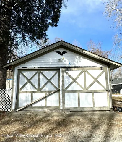 a front view of a house with a yard covered with snow and trees